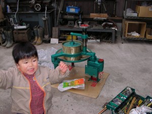 輸入した手摘み用小型揉捻機と長男（円い桶の直径は約20cm）。2006年冬